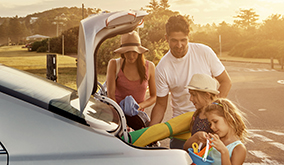 family getting beach toys out of trunk