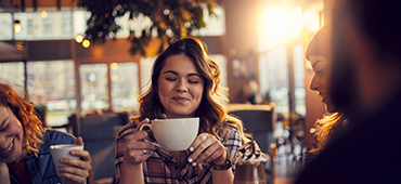 woman sitting in coffee shop holding mug