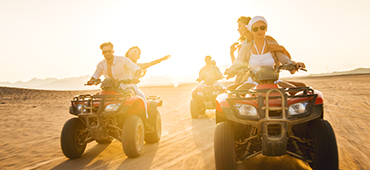 couples driving ATVs through desert